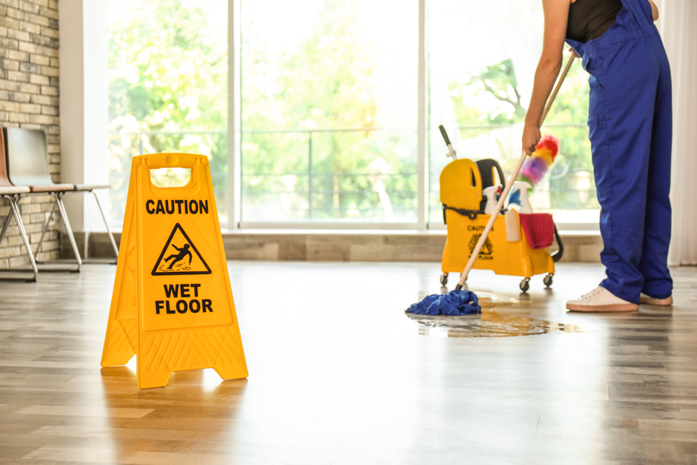 Commercial cleaner mopping hard wood floors in a commercial space.