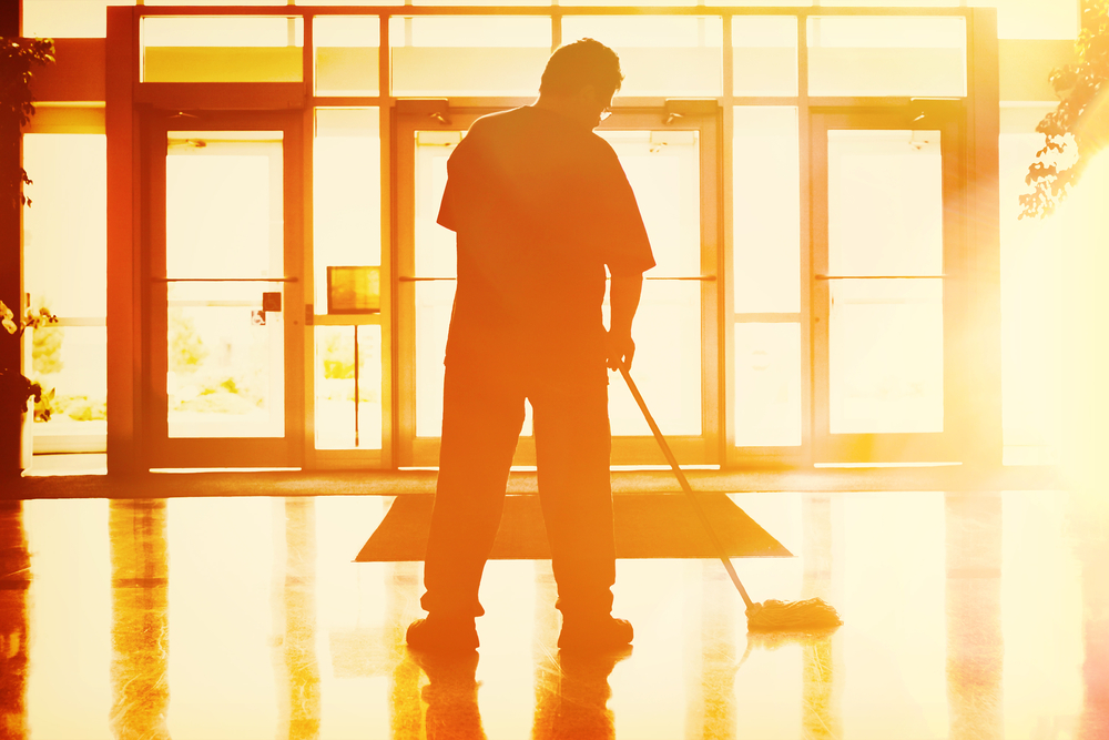 Man sweeping a front foyer area during a commercial cleaning service.
